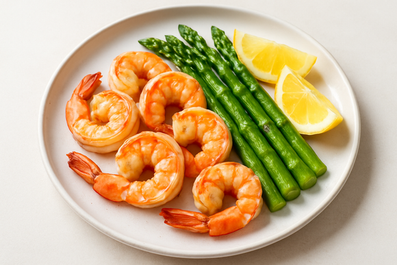 gulf shrimp head off cooked on plate with asparagus and lemon wedges